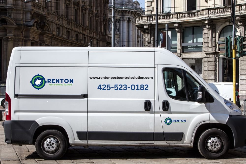 A white van parked on the roadside, associated with a pest control service in Renton, WA.